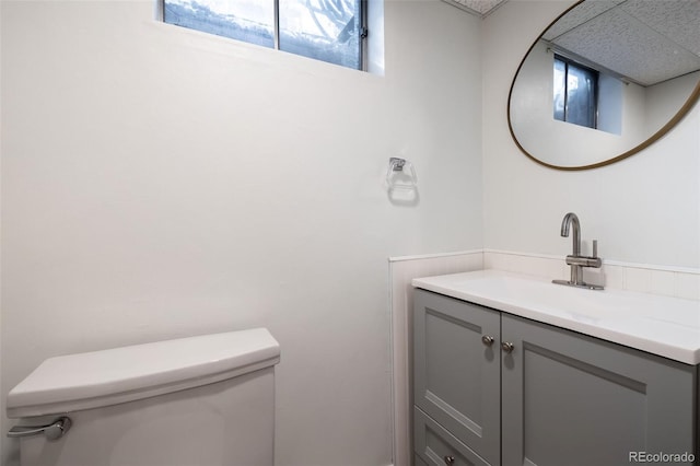 bathroom with toilet, vanity, and plenty of natural light