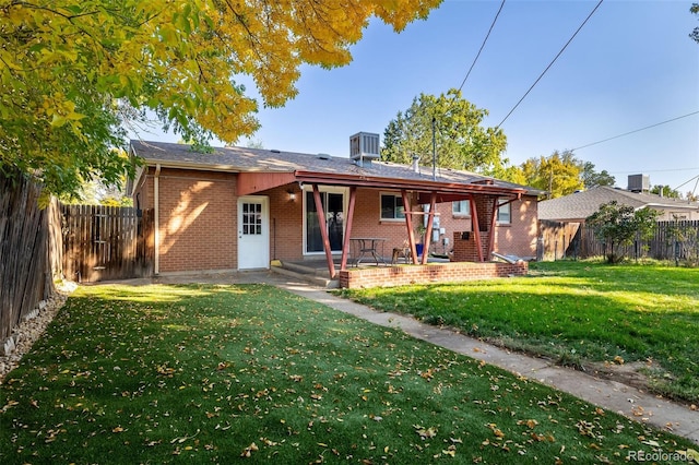 rear view of property with a lawn and a patio