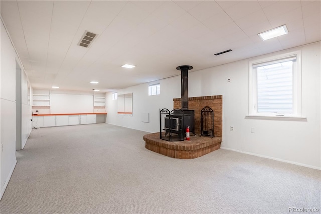 basement featuring carpet and a wood stove