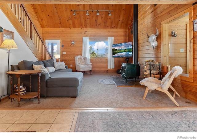 1666 High Creek Rd, Fairplay, CO 80440 - tiled living room featuring rail lighting, a wood stove, wood walls, stairway, and wooden ceiling