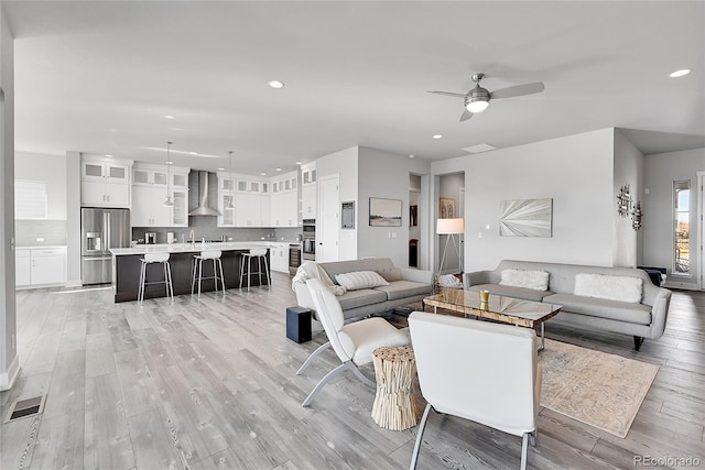 living room featuring light wood-type flooring and ceiling fan