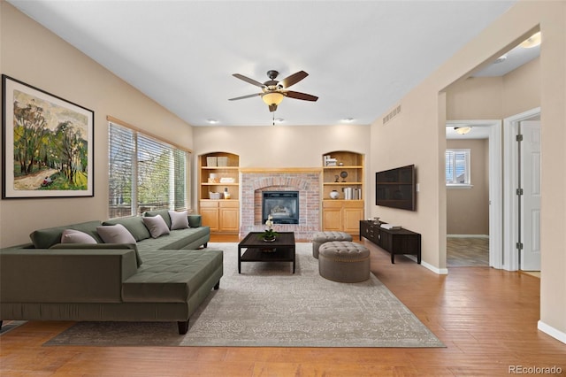 8985 Edgewood Ln, Highlands Ranch, CO 80130 - living room featuring a ceiling fan, built in shelves, baseboards, and plenty of natural light