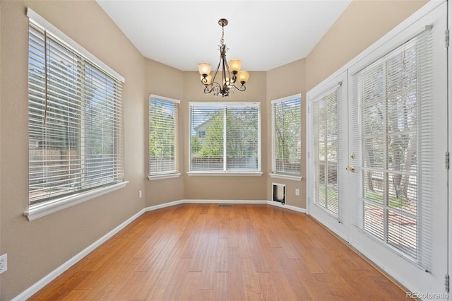 8985 Edgewood Ln, Highlands Ranch, CO 80130 - unfurnished sunroom with wood finished floors, a chandelier, plenty of natural light, and baseboards