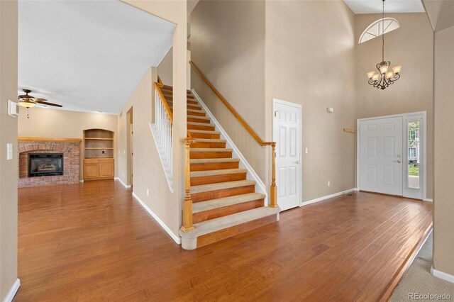 8985 Edgewood Ln, Highlands Ranch, CO 80130 - foyer entrance featuring ceiling fan, baseboards, wood finished floors, stairs, and a towering ceiling
