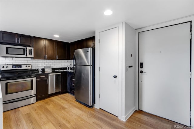 2193 Arapahoe St Unit 15, Denver, CO 80205 - kitchen with stainless steel appliances, dark brown cabinets, dark countertops, backsplash, and light wood-type flooring