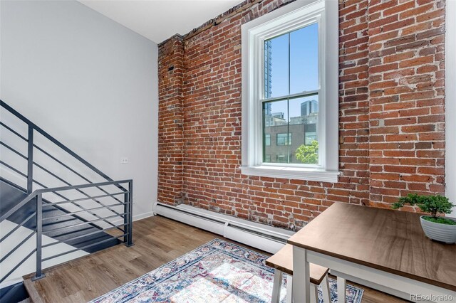 2193 Arapahoe St Unit 15, Denver, CO 80205 - interior space featuring baseboard heating, brick wall, wood finished floors, and baseboards
