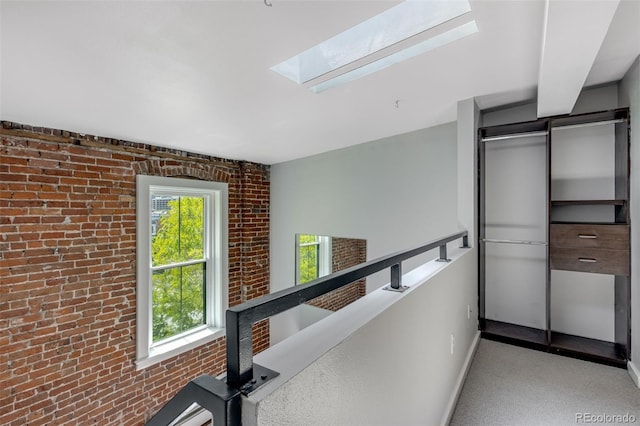 2193 Arapahoe St Unit 15, Denver, CO 80205 - hallway featuring a skylight, brick wall, and baseboards