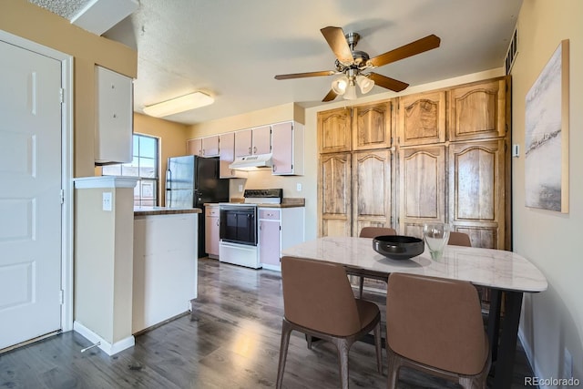 kitchen with electric range, visible vents, dark wood-style floors, freestanding refrigerator, and under cabinet range hood