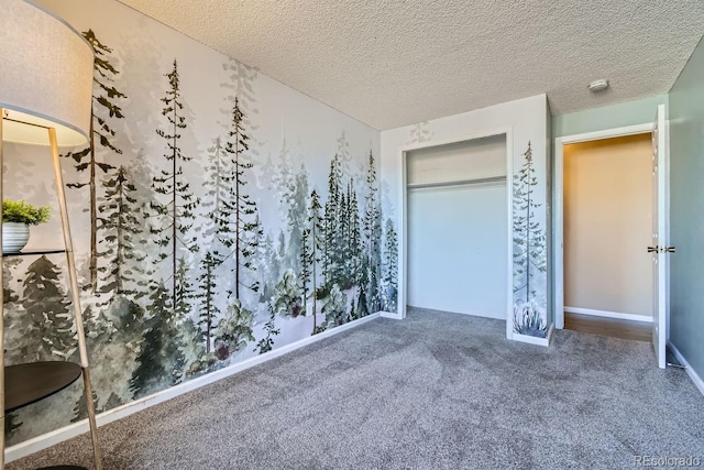 unfurnished bedroom with carpet floors, a textured ceiling, a closet, and baseboards