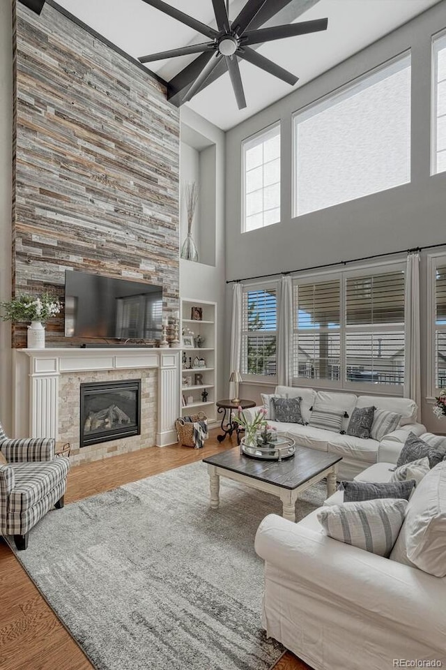 26566 E Peakview Dr, Aurora, CO 80016 - living area featuring a high ceiling, a ceiling fan, wood finished floors, and a tile fireplace