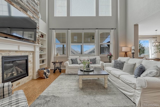 26566 E Peakview Dr, Aurora, CO 80016 - living room with a glass covered fireplace, built in shelves, a high ceiling, and wood finished floors