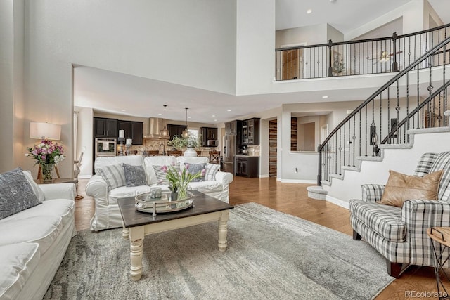 26566 E Peakview Dr, Aurora, CO 80016 - living area with baseboards, stairs, a towering ceiling, and wood finished floors