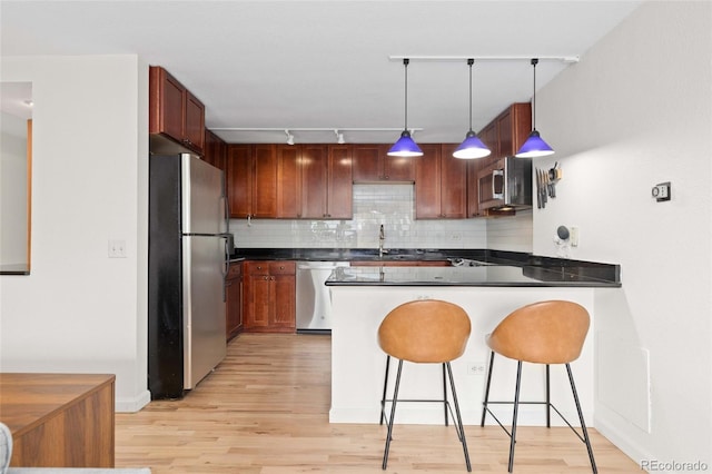 1150 Vine St Unit 306, Denver, CO 80206 - kitchen featuring stainless steel appliances, a sink, light wood-style floors, and a peninsula