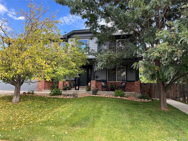 view of front of home featuring a front yard, a garage, and a porch