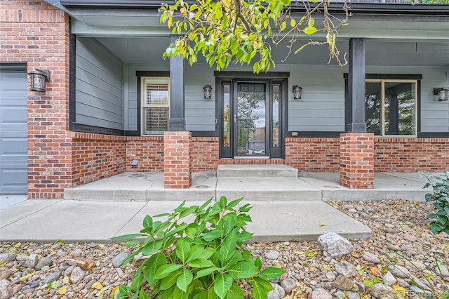 doorway to property featuring covered porch and a garage