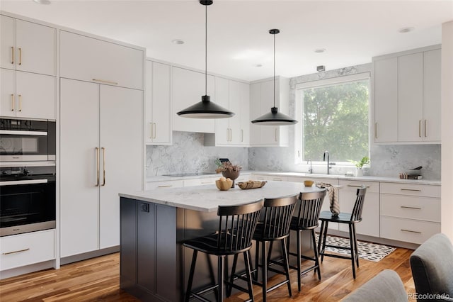 3130 Wyandot St, Denver, CO 80211 - kitchen featuring a breakfast bar, light wood finished floors, and backsplash