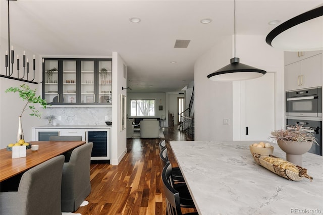 3130 Wyandot St, Denver, CO 80211 - kitchen with wine cooler, double oven, dark wood finished floors, recessed lighting, and glass insert cabinets