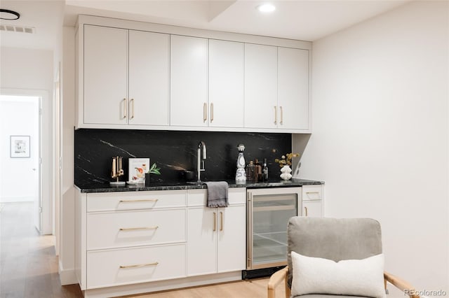 3130 Wyandot St, Denver, CO 80211 - indoor wet bar featuring wine cooler, tasteful backsplash, light wood-style floors, and recessed lighting