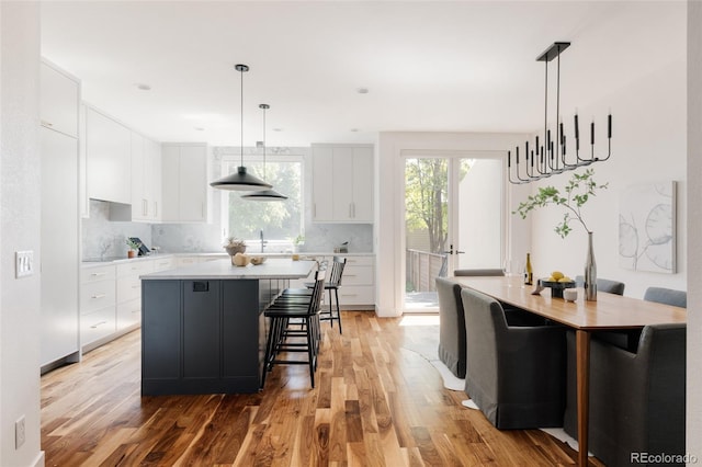 3130 Wyandot St, Denver, CO 80211 - kitchen with light wood-style floors, a kitchen island, light countertops, and tasteful backsplash