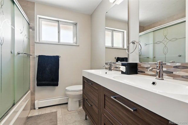 3691 Allison St, Wheat Ridge, CO 80033 - bathroom featuring a baseboard heating unit, toilet, combined bath / shower with glass door, double vanity, and decorative backsplash