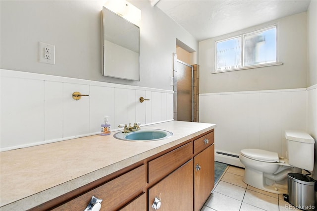 3691 Allison St, Wheat Ridge, CO 80033 - bathroom with baseboard heating, wainscoting, toilet, vanity, and tile patterned floors