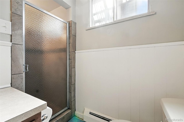 3691 Allison St, Wheat Ridge, CO 80033 - bathroom featuring a baseboard heating unit, a stall shower, toilet, and a wainscoted wall