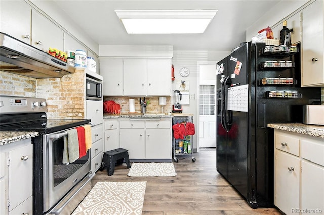 3691 Allison St, Wheat Ridge, CO 80033 - kitchen with stainless steel range with electric stovetop, exhaust hood, black fridge, light wood-style flooring, and light countertops