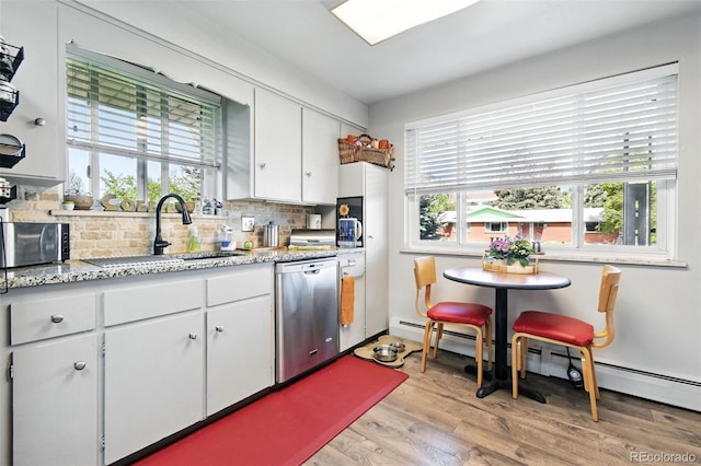3691 Allison St, Wheat Ridge, CO 80033 - kitchen with a sink, stainless steel appliances, tasteful backsplash, white cabinetry, and light wood-type flooring