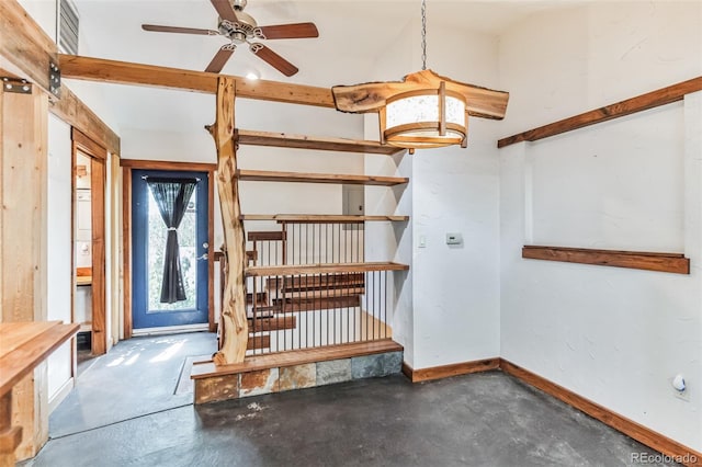 interior space featuring concrete flooring, a ceiling fan, and baseboards