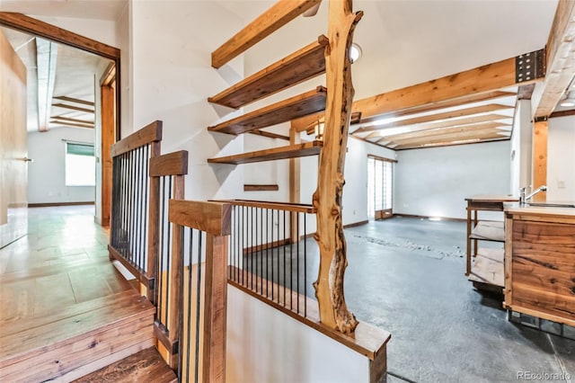 stairway featuring beam ceiling and baseboards