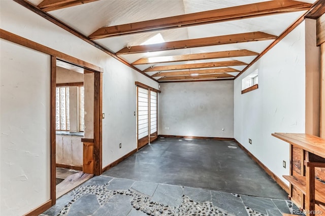 empty room with vaulted ceiling with beams