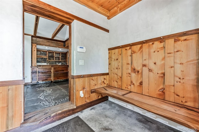 mudroom featuring a wainscoted wall, wooden ceiling, and wooden walls