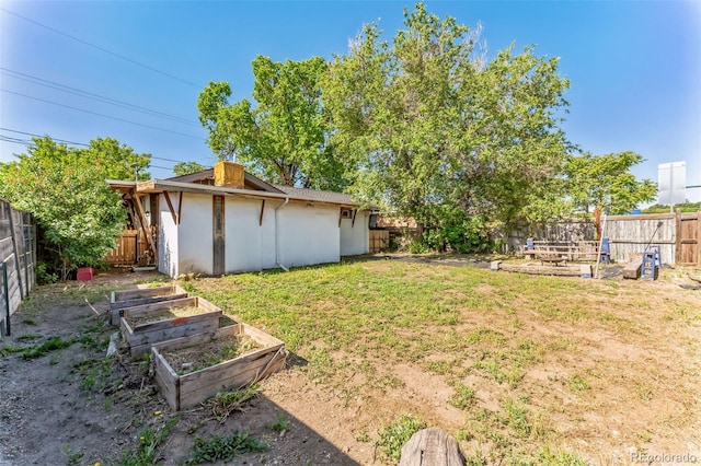 view of yard with a garden and a fenced backyard