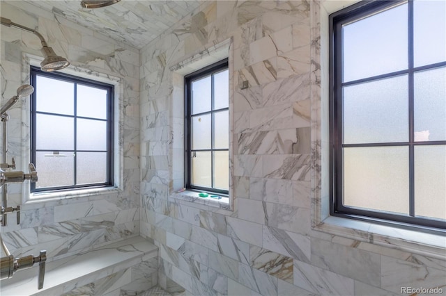 interior space with a tile shower and a wealth of natural light