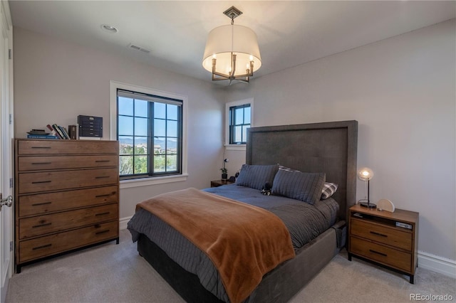 bedroom featuring an inviting chandelier, baseboards, visible vents, and light colored carpet