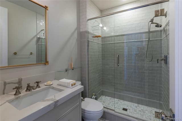 bathroom with vanity, a stall shower, and toilet