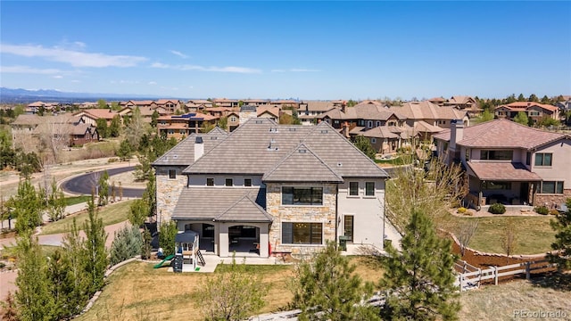 rear view of property with a residential view, a fenced backyard, a patio area, and stone siding
