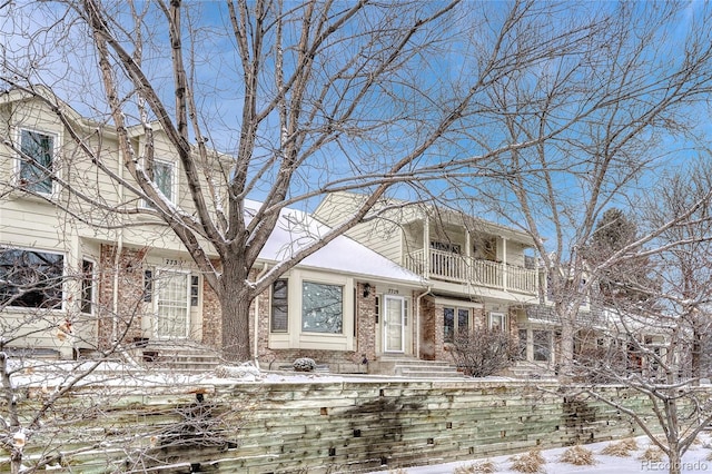 view of front of house with a balcony and brick siding