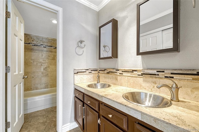 bathroom featuring double vanity, a sink, washtub / shower combination, and crown molding