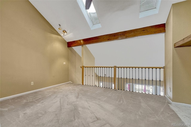 spare room with high vaulted ceiling, a skylight, beam ceiling, and light carpet