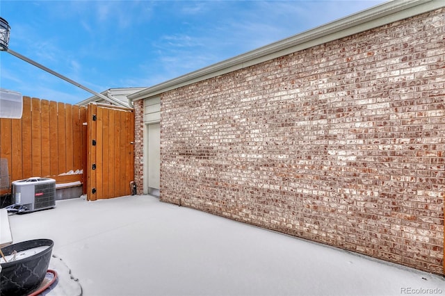 view of patio / terrace with a garage, a gate, fence, and central AC