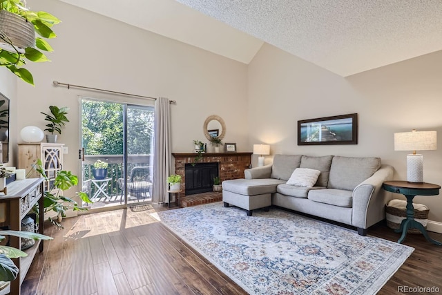 living room featuring dark wood-type flooring, a textured ceiling, a brick fireplace, and high vaulted ceiling