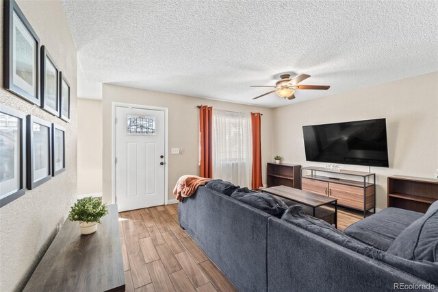 1940 Carmel Dr, Colorado Springs, CO 80910 - living area featuring a textured ceiling, wood finished floors, and a ceiling fan