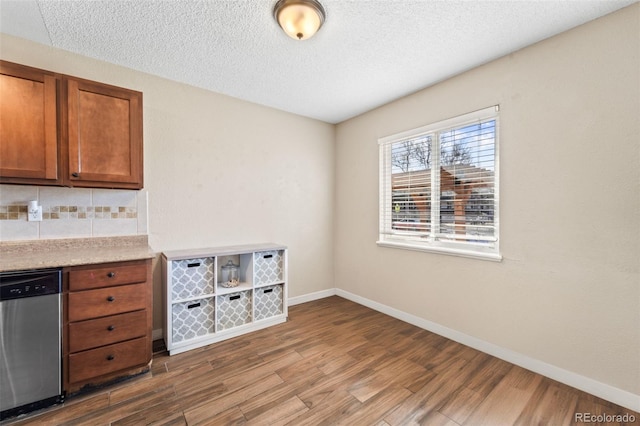 1940 Carmel Dr, Colorado Springs, CO 80910 - interior space with wood finished floors, stainless steel dishwasher, baseboards, and backsplash