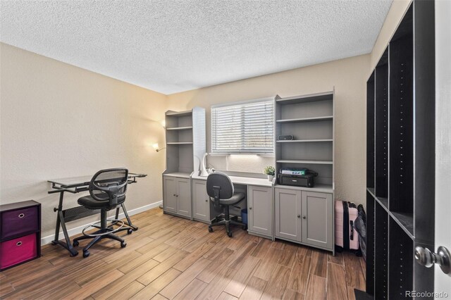 1940 Carmel Dr, Colorado Springs, CO 80910 - home office with a textured ceiling, light wood finished floors, and baseboards