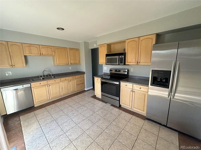 kitchen featuring a sink, stainless steel appliances, dark countertops, and light brown cabinets