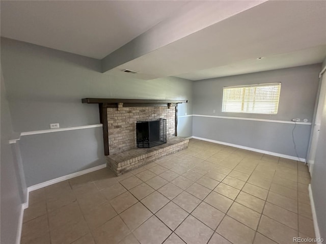 unfurnished living room featuring tile patterned flooring, visible vents, a fireplace, and baseboards