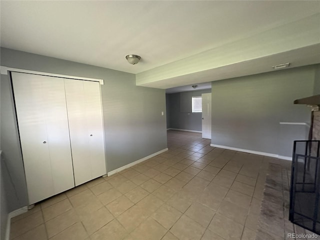 interior space with light tile patterned floors, visible vents, baseboards, and a brick fireplace