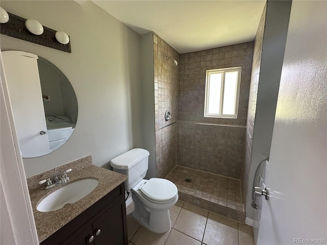 full bath with vanity, tile patterned floors, toilet, and a tile shower