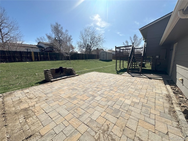 view of patio with a shed, a wooden deck, a fenced backyard, stairs, and an outdoor structure